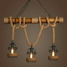 three light fixtures hanging from a rope and wood chandelier