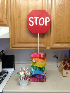 a red stop sign sitting on top of a stack of candy bars in a kitchen