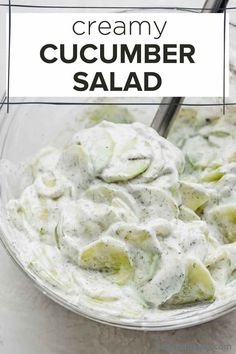 creamy cucumber salad in a glass bowl with a spoon