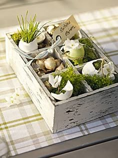 a wooden box filled with plants on top of a checkered tablecloth covered table