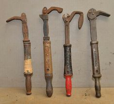 five old tools are lined up on a shelf