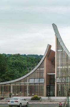 a car is parked in front of a building with an unusual design on it's side