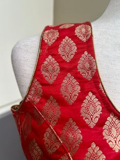 Pure Banarasi Red Color Blouse with Gold Buttis in Zari Weaving. Comes with Cups attached to the blouse. Please note : Blouses has margin to open 2 sizes up. Item : Ready to Wear BlouseColor : Red Sleeves : Sleeveless (Does not come with Sleeves)Blouse Fabric : Pure Banarasi SilkBlouse Fitting : Princess Cut Lining : Yes, it is fully lined Padded or Non-Padded : Padded Closure: Back Closure with hooks.Ready-to-Wear : YesDisclaimer - :-This is a Standard Size blouse. We do not guarantee perfect f Traditional Sleeveless Blouse Piece For Eid, Anarkali Blouse For Eid Celebration, Anarkali Style Blouse For Eid Celebration, Festive Traditional Drape Tops For Eid, Resham Embroidery Blouse For Eid Celebration, Eid Celebration Blouse With Resham Embroidery, Art Silk Blouse For Eid Celebration, Festive Tops With Traditional Drape For Eid, Traditional Chanderi Tops For Party