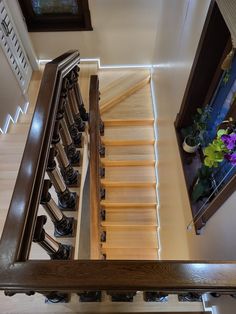 an overhead view of a staircase with wooden handrails