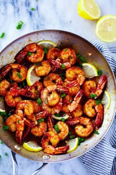 a pan filled with cooked shrimp and lemon slices