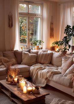 a living room filled with lots of furniture and candles on the coffee table in front of a large window