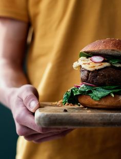 a person holding a tray with a hamburger on it