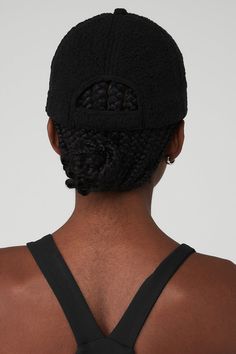 the back of a man wearing a black hat with braids on it's sides