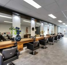 an empty salon with chairs and tables in the center, facing towards the back wall