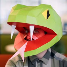 a man is wearing a paper mask with an alligator's head on it