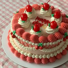 a cake decorated with cherries and hearts on a tableclothed table cloth is ready to be eaten