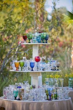 a three tiered tray filled with glasses on top of a table