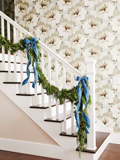 the garland on the banister is tied with blue ribbon