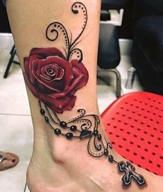 a woman's foot with a rose tattoo on the side of her leg,