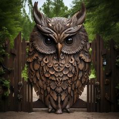 an owl statue sitting on top of a wooden fence