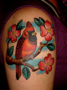 a woman's arm with a bird and flowers on it