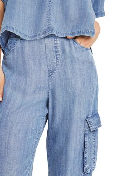 Lightweight chambray pants feature a comfortable elastic waist, wide legs and trendy cargo pockets for a look you'll love. 31 1/2" inseam; 9" leg opening; 10" front rise; 13 1/2" back rise Zip fly with button closure; elastic waist Five-pocket style; cargo flap-patch pockets 100% lyocell Machine wash, tumble dry Imported Linen Cargo-style Bottoms, Relaxed Fit Linen Cargo Bottoms, Relaxed Fit Linen Cargo Style Bottoms, Spring Cargo Pocket Jeans For Elevated Casual, Spring Relaxed Fit Cropped Cargo Jeans, Spring Cropped Leg Cargo Jeans With Relaxed Fit, Relaxed Fit Wide Leg Bottoms With Cargo Pockets, Spring Cropped Leg Relaxed Fit Cargo Jeans, Spring Cargo Jeans With Relaxed Fit And Cropped Leg