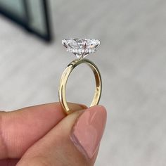 a person holding a ring with a diamond in it's center and two diamonds on the side