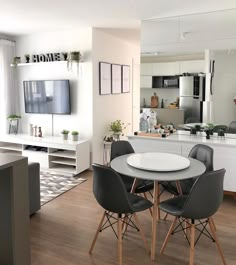 a dining room table and chairs in front of a tv