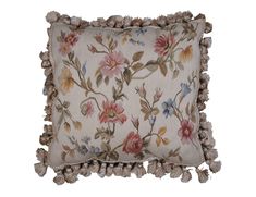 an embroidered pillow with tasselled edges and flowers on the front, sitting on a white background