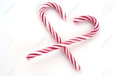 two candy canes in the shape of a heart on a white background stock photo