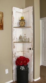 an old door is open to reveal a shelf with flowers in it and a clock on the wall