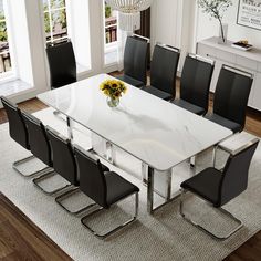 a dining room table with chairs and a vase filled with flowers