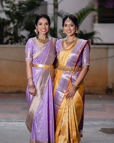 two women standing next to each other in sari