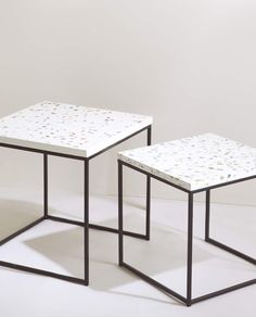 two tables sitting side by side on top of each other in front of a white wall