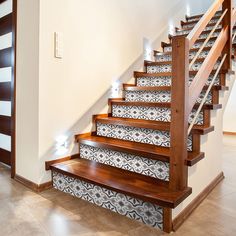 the stairs are decorated with black and white tile designs, along with wooden handrails