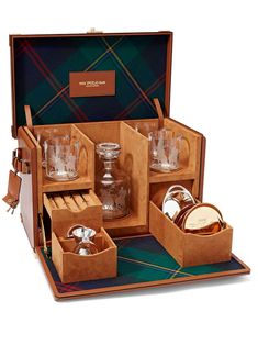 an open wooden box with glassware in it on a plaid tableclothed surface