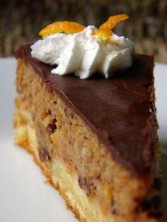 a piece of cake on a plate with whipped cream and orange zest garnish