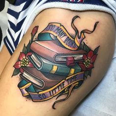 a woman's thigh with books and flowers on it