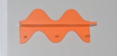 an orange shelf with two hooks on it