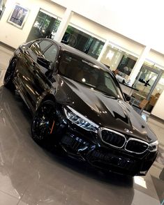 a black car is parked in a showroom