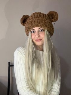 a woman with long blonde hair wearing a bear hat