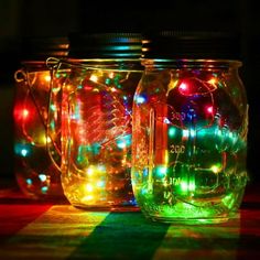 three mason jars with christmas lights in them