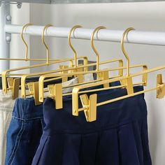 three pairs of pants hanging on clothes racks