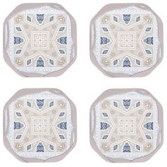 four blue and white coasters with an intricate design on the top, one in the middle