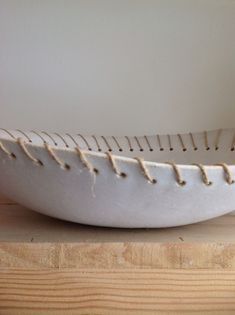 a white bowl sitting on top of a wooden table