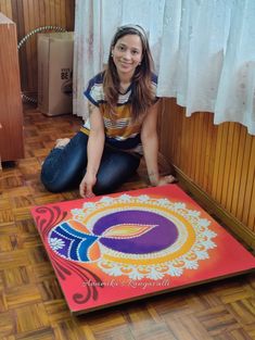 a woman sitting on the floor in front of a painting