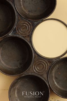 an old frying pan with six empty dishes in it's center and the words fuson mineral paint on top