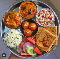 a metal plate topped with different types of food next to rice and veggies