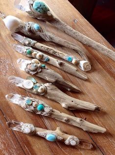 five pieces of wood sitting on top of a wooden table covered in turquoise stones and beads