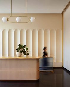 a woman walking past a counter in a lobby