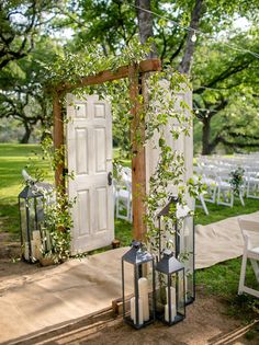 an outdoor ceremony set up with lanterns and greenery