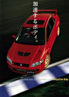 a red car driving down a race track with japanese writing on it's side