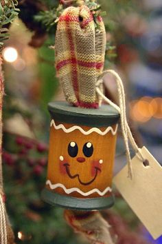 a christmas ornament hanging from the side of a tree with a smiley face on it