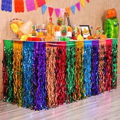 a colorful party table with streamers and confetti