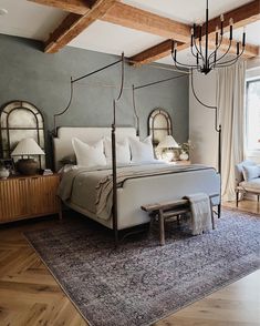 a bedroom with a canopy bed and chandelier hanging from the ceiling above it